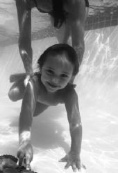 black and white image of child enjoying being underwater ... by Fiona Ayerst 